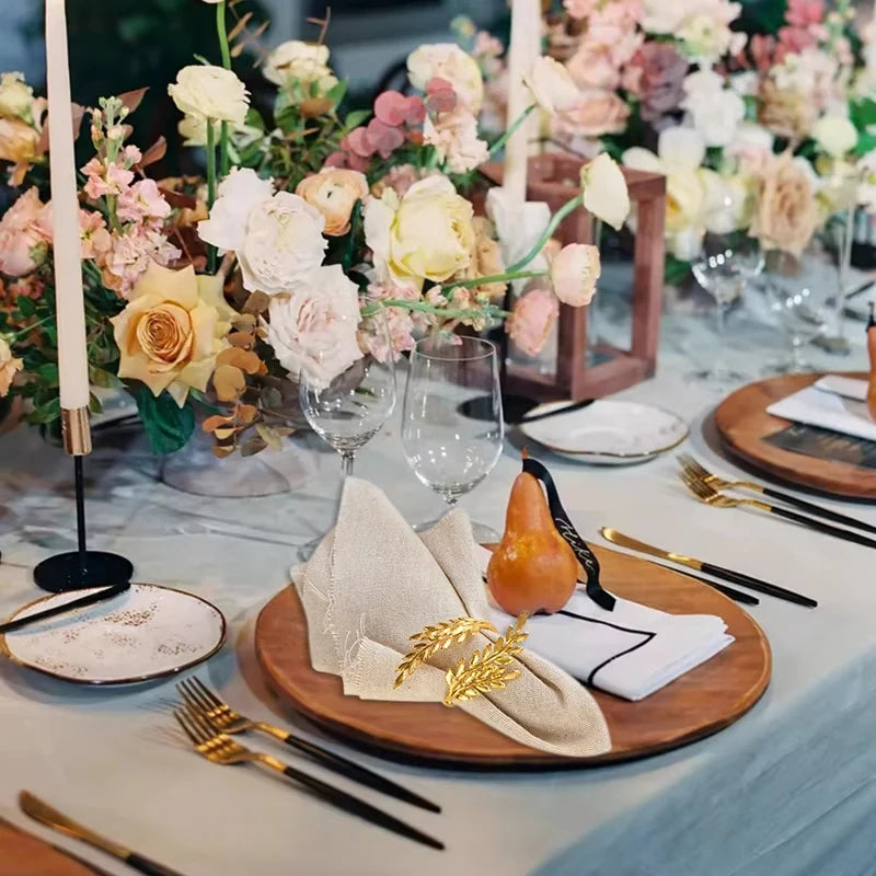 Table avec un chemin de table en velours vert, des ronds de serviette dorés et des bougies LED